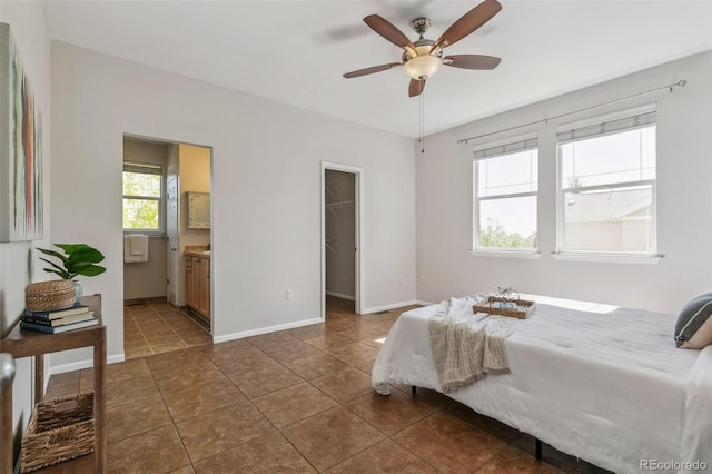 14247 W 84th Cir Unit A, Arvada, CO 80005 - bedroom with a spacious closet, dark tile patterned floors, ensuite bathroom, ceiling fan, and a closet