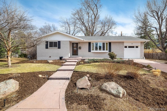 single story home featuring a front yard, fence, concrete driveway, a garage, and brick siding