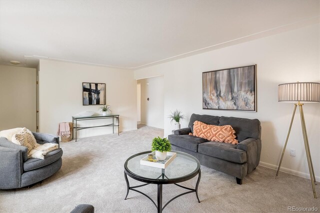 living room featuring baseboards and light colored carpet