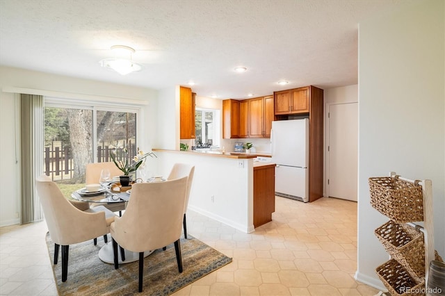 dining space featuring recessed lighting, a textured ceiling, and baseboards