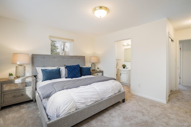 carpeted bedroom with connected bathroom and baseboards