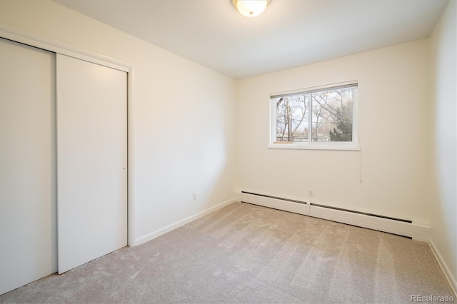 unfurnished bedroom featuring carpet flooring, a closet, and a baseboard radiator