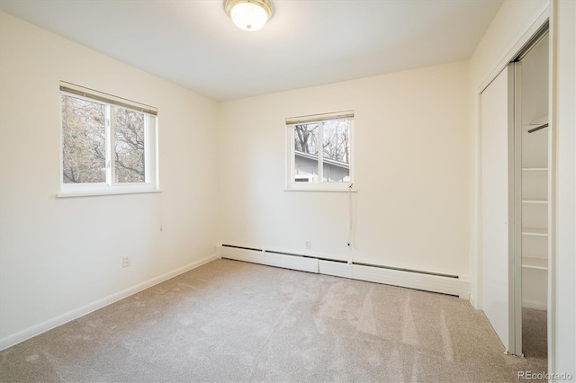 unfurnished bedroom featuring a closet, baseboard heating, and carpet