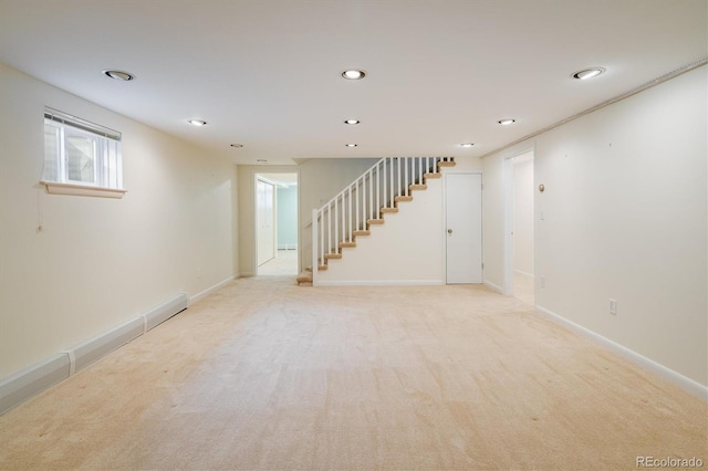 below grade area featuring recessed lighting, light colored carpet, stairs, and baseboards