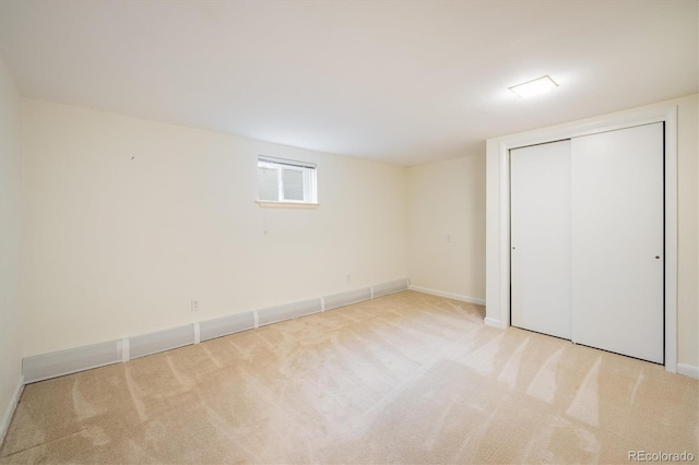 unfurnished bedroom with carpet, a closet, and baseboards