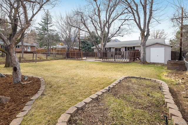 view of yard featuring a storage unit, an outbuilding, and a fenced backyard