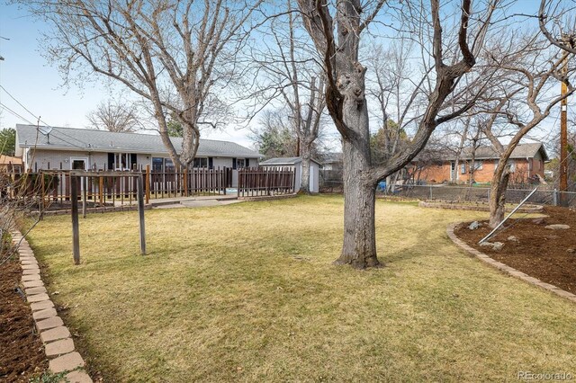 view of yard featuring an outbuilding, a storage unit, a fenced backyard, and a wooden deck