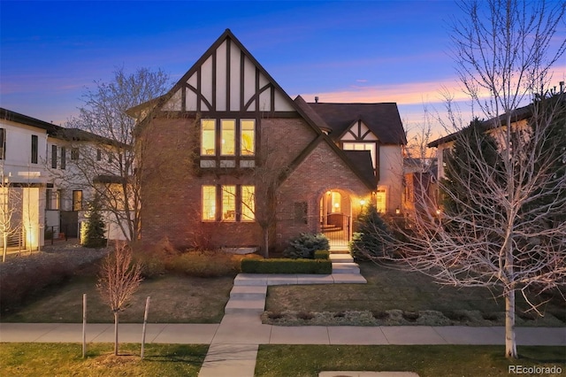 tudor-style house featuring a lawn