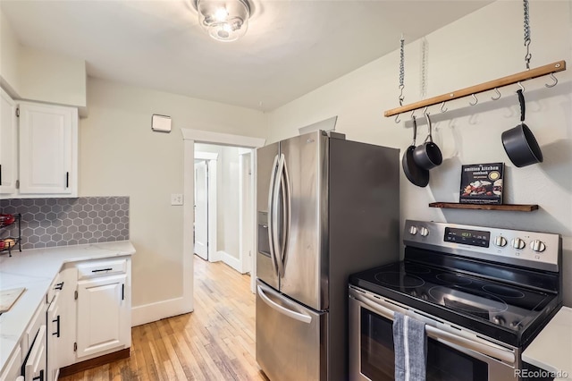 4057 Bryant St, Denver, CO 80211 - kitchen with appliances with stainless steel finishes, light wood finished floors, white cabinets, light stone countertops, and decorative backsplash