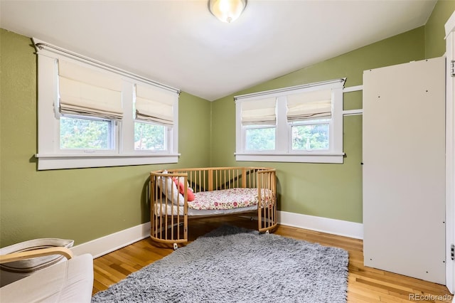 4057 Bryant St, Denver, CO 80211 - bedroom with vaulted ceiling, multiple windows, light wood-type flooring, and a crib