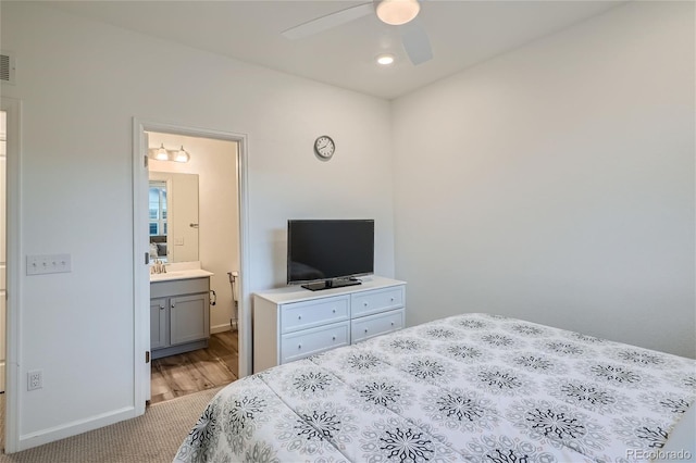 bedroom featuring ensuite bathroom, baseboards, carpet floors, and ceiling fan