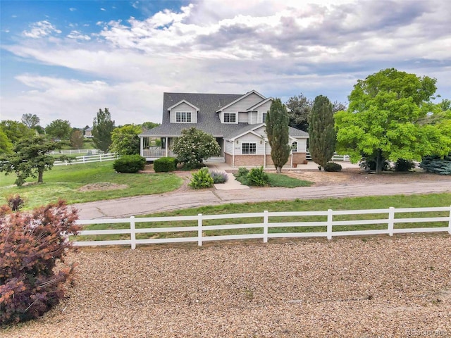 10170 E 151st Ct, Brighton, CO 80602 - view of front of house featuring a porch, driveway, roof with shingles, and brick siding