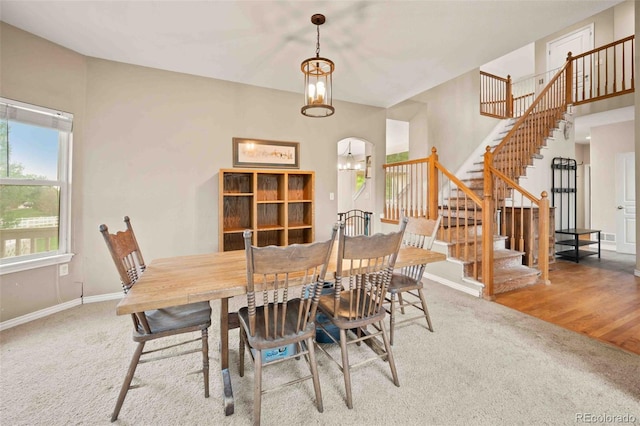 10170 E 151st Ct, Brighton, CO 80602 - dining space featuring carpet flooring, stairway, baseboards, and a chandelier