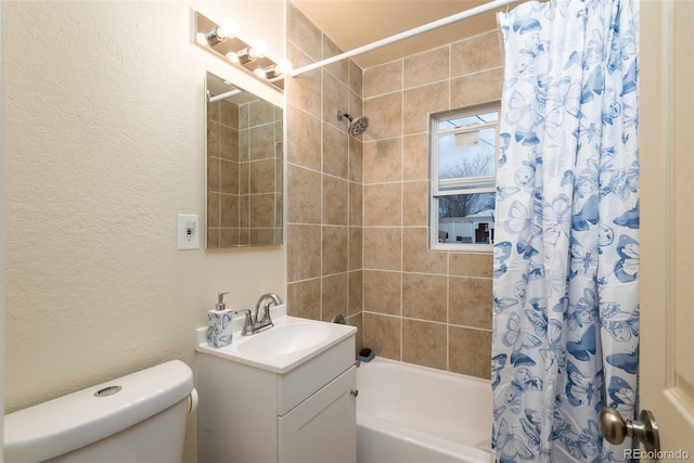 bathroom with shower / bath combo, a textured wall, vanity, and toilet