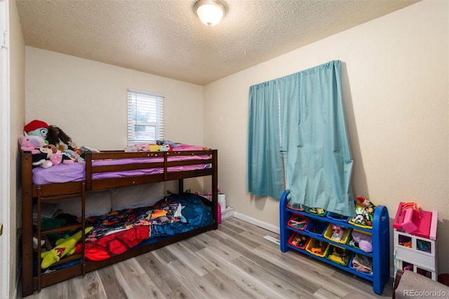 bedroom featuring a textured ceiling and wood finished floors