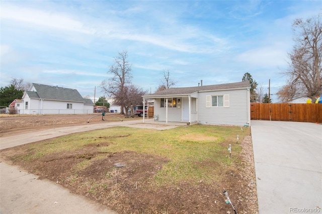 view of front of home with driveway, a front lawn, fence, and a gate