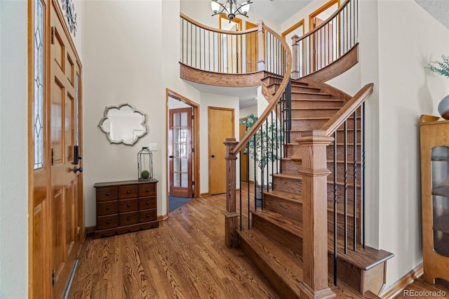 entryway featuring a high ceiling, an inviting chandelier, and hardwood / wood-style flooring