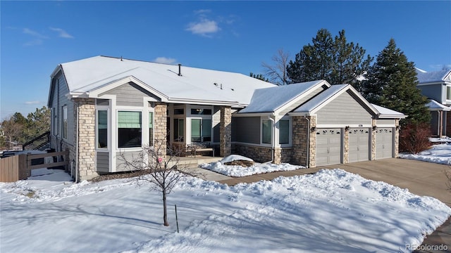 view of front facade featuring a garage, stone siding, and driveway