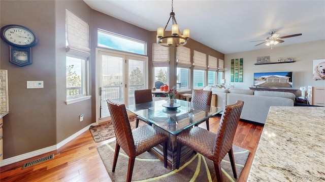 dining area featuring french doors, a notable chandelier, visible vents, light wood-style floors, and baseboards