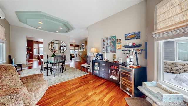 living area featuring light wood-type flooring, baseboards, and wine cooler