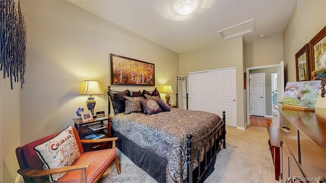 carpeted bedroom with attic access, baseboards, and a closet