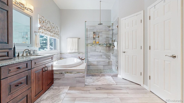 bathroom featuring a stall shower, vanity, and a bath