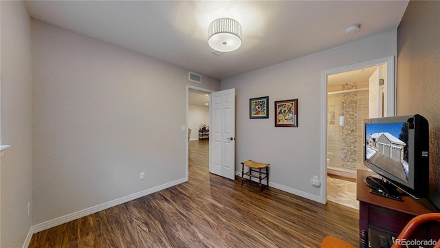 bedroom featuring visible vents, baseboards, and wood finished floors