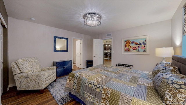 bedroom with visible vents, baseboards, and wood finished floors