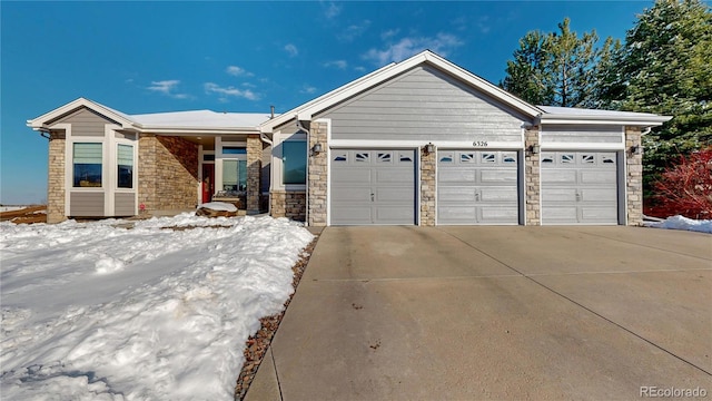 ranch-style house with a garage, stone siding, and driveway