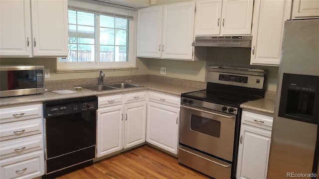 kitchen featuring a sink, stainless steel appliances, white cabinets, light wood-style floors, and under cabinet range hood