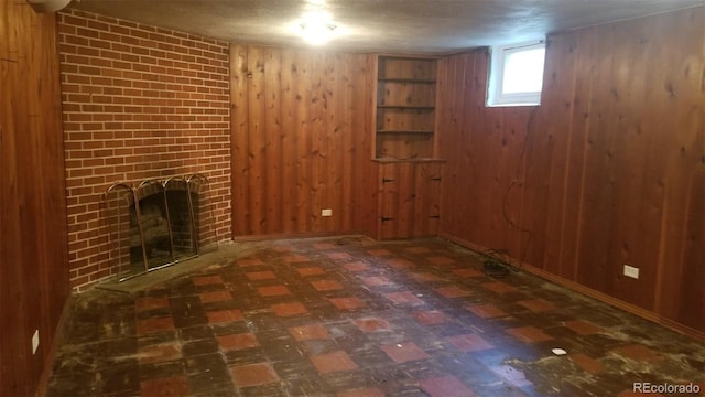 basement with tile patterned floors, wooden walls, and a fireplace