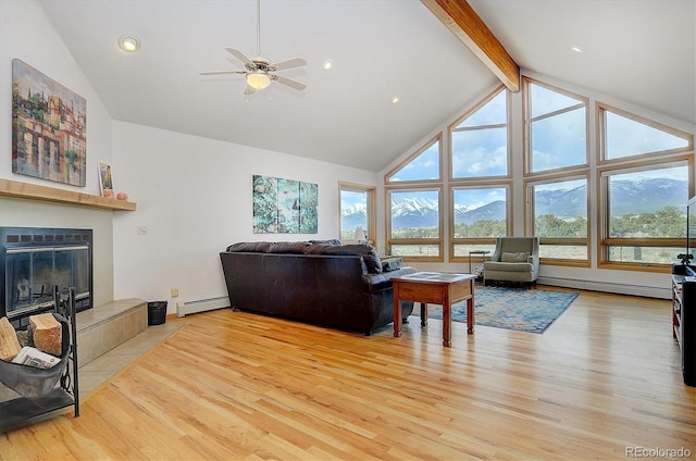 living room featuring beam ceiling, a mountain view, a baseboard heating unit, and light hardwood / wood-style floors