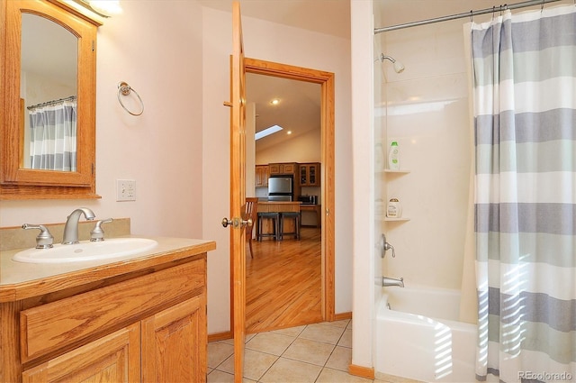 bathroom with shower / tub combo with curtain, vanity, vaulted ceiling, and tile patterned floors