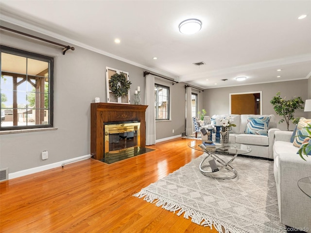 living room featuring light hardwood / wood-style flooring and ornamental molding