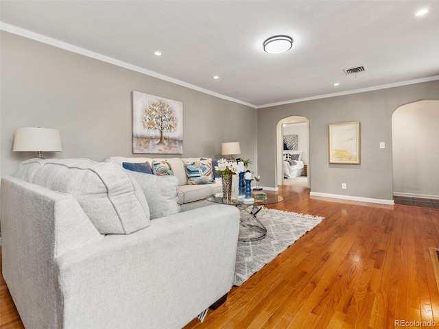 living room with wood-type flooring and ornamental molding