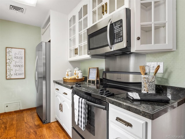 kitchen featuring hardwood / wood-style flooring, white cabinets, and stainless steel appliances