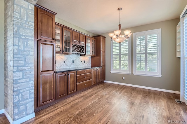 kitchen with decorative backsplash, decorative light fixtures, dark hardwood / wood-style floors, and a notable chandelier