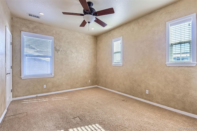 spare room featuring carpet flooring, ceiling fan, and a textured ceiling