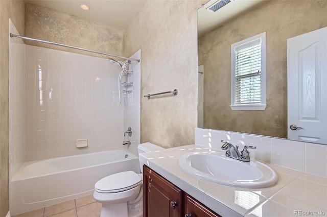 full bathroom featuring toilet, vanity, tiled shower / bath combo, and tile patterned floors