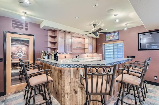 kitchen featuring a kitchen breakfast bar, kitchen peninsula, and ceiling fan