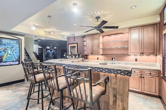 kitchen featuring a kitchen bar, a center island, and ceiling fan