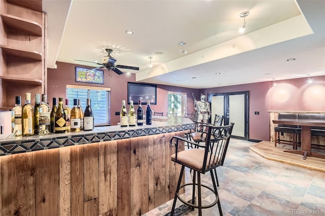 bar with ceiling fan and a healthy amount of sunlight