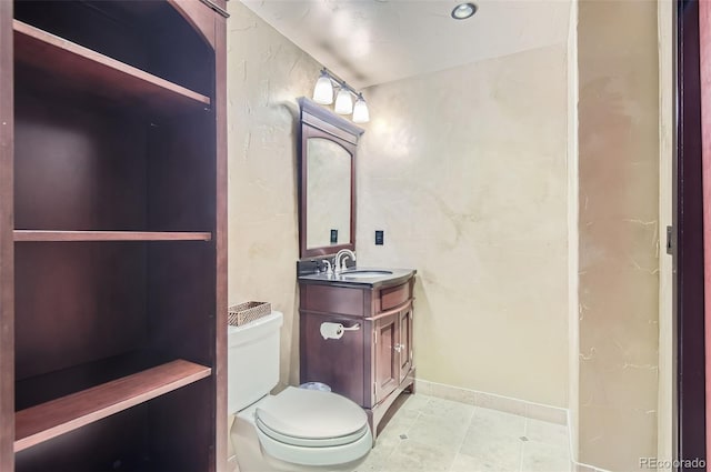 bathroom with tile patterned flooring, vanity, and toilet