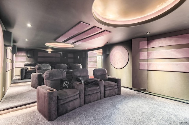 carpeted home theater room with a tray ceiling