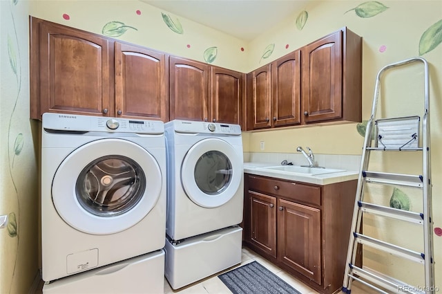 clothes washing area with cabinets, light tile patterned floors, separate washer and dryer, and sink