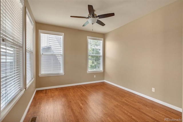 spare room with baseboards, ceiling fan, and wood finished floors