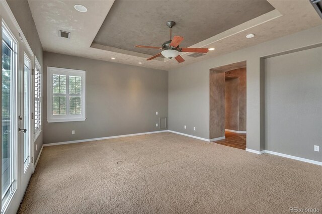 carpeted empty room featuring baseboards, recessed lighting, a raised ceiling, and ceiling fan