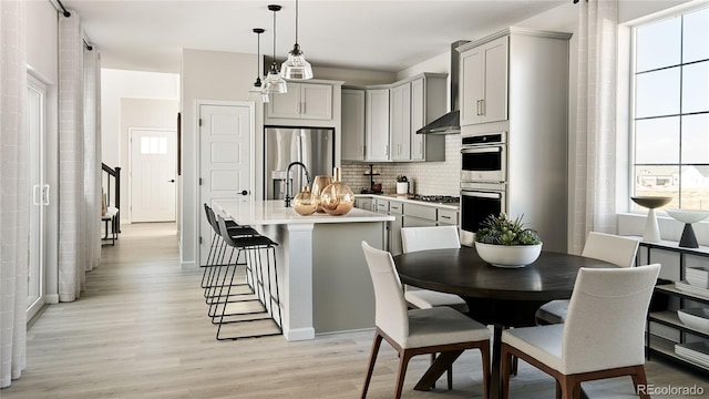 6601 E 148th Dr, Thornton, CO 80602 - kitchen featuring decorative backsplash, light wood-type flooring, gray cabinetry, light countertops, and stainless steel appliances