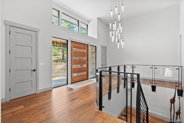 foyer with light wood-type flooring and a towering ceiling