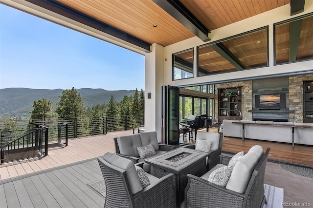 wooden deck featuring a mountain view and an outdoor living space with a fireplace